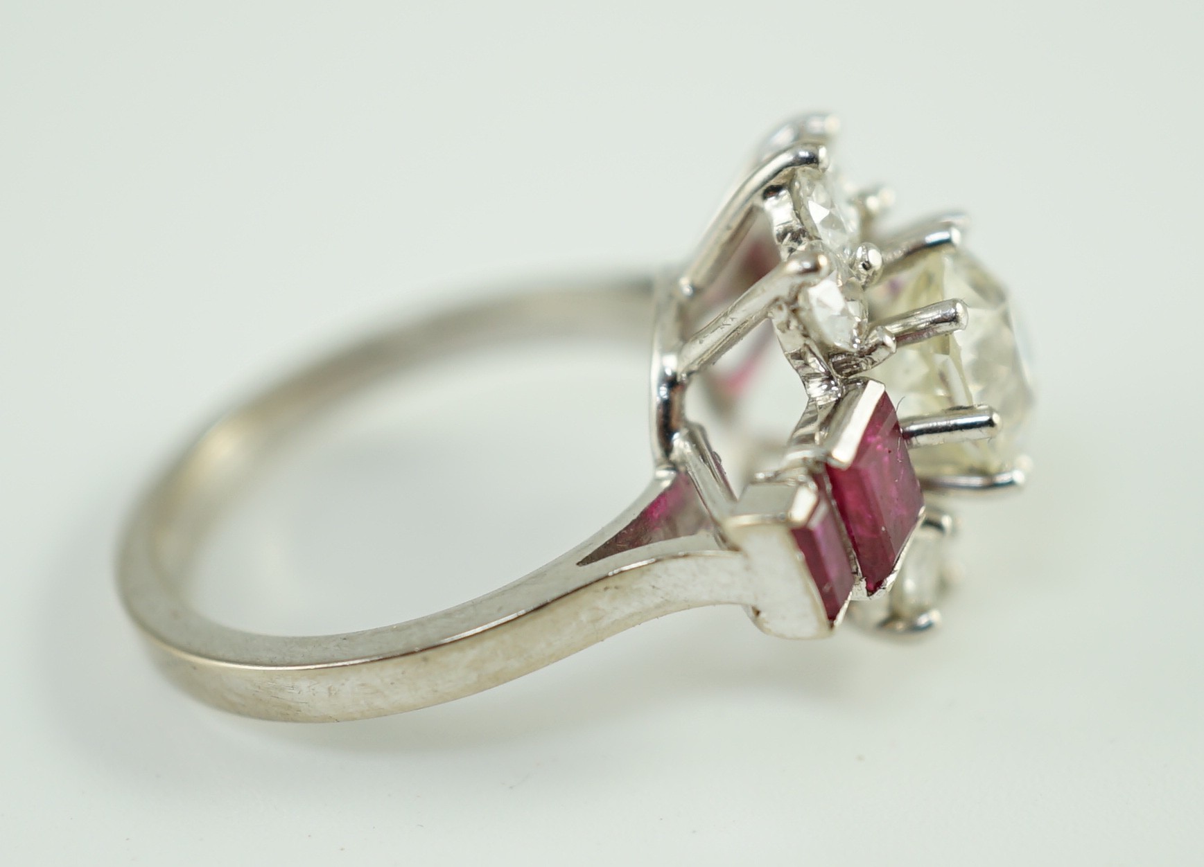 A platinum and single stone diamond dress ring, bordered by six round cut diamond and each shoulder set with two graduated rectangular rubies